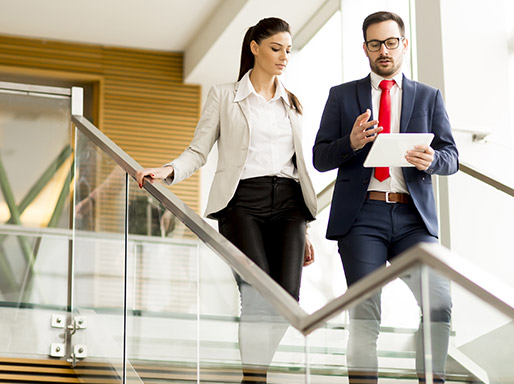 colleagues walking down stairs in modern lobby