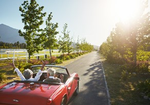 Man and woman driving in a car celebrating retirement 